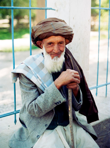 man leans against fence in Kabul